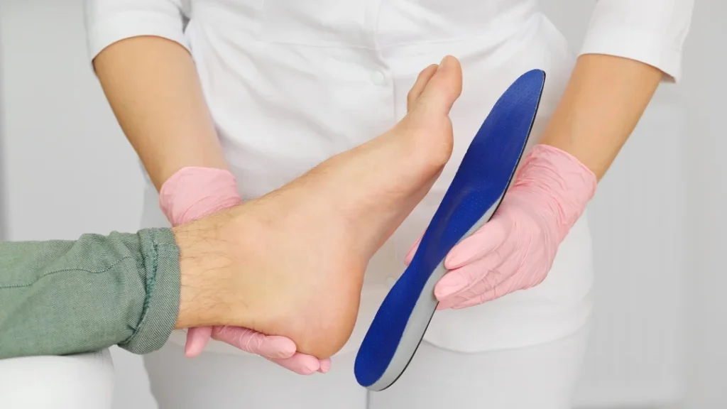 Une personne se fait examiner le pied par un médecin dans un cabinet médical.